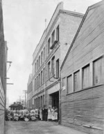 Exterior of the Wellington Woodware Co factory, with the men of the company standing alongside