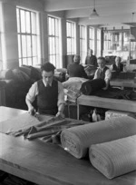 Men working with rolls of fabric