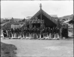 Outside Te Rauru meeting house at Whakarewarewa village, with Maori women performing an action song