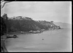 Bay near Port Chalmers, with boatsheds on the waterfront and small boats moored off-shore