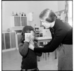 Eyesight check of a young girl, and, a couple in a room