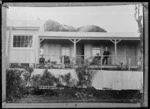 Group on the verandah of the caretaker's house, at Dawson Falls, Mount Taranaki - Photograph taken by David Duncan