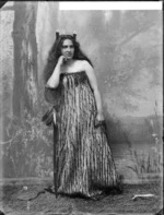 Studio portrait of a young woman wearing traditional Maori clothing - Photographed by William Henry Thomas Partington