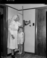 Boy being weighed at King George V Memorial Health Camp for Children, Pakuranga, Auckland - Photograph taken by Edward Percival Christensen