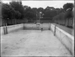 Man sweeping an empty swimming pool, Christ's College, Christchurch