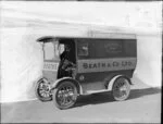 Man behind the wheel of a Walker electric van, Beath & Company Ltd written on side, Christchurch
