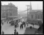 View of Colombo Street, Christchurch, looking toward Cathedral Square with trams, cyclists and pedestrians in the foreground