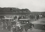 Creator unknown : Group watching a biplane in the air at Wellington Airport