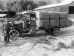 Man, children, and truck carrying wool bales