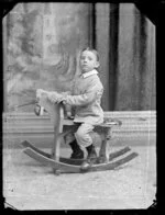 Unidentified little boy on rocking horse