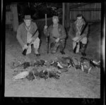 Unidentified hunters pose with dead birds, including ducks and geese, at the opening of the duck shooting season