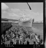 A large crowd watches the passenger ship Southern Cross pull out from the wharf at Wellington