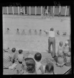 Mr J Hutchison teaching children to swim [Thorndon Pool?]