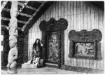 Maori meeting house Te Rauru at Whakarewarewa, and young Maori woman by the doorway