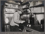 Herbert George Ponting working in the dark room of Scott's hut, Antarctica