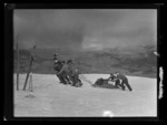 Skiers dragging and pushing sled up Coronet Peak, Queenstown