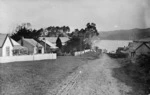 View of Rawene showing dirt road and houses with picket fences