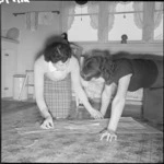 Mrs Holmes and a neighbour cutting a pattern, 32 Naenae Road, Hutt Valley