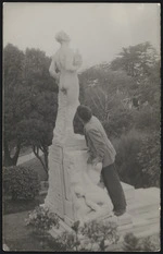 Man examining the Harry Holland memorial sculpture