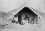 Creator unknown: Photograph of a group at Guide Sophia's buried whare at Te Wairoa, Rotorua district, after the 1886 eruption of Mount Tarawera, taken by the Burton Brothers