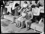 Spectators and team members poolside watching a dive, 1950 British Empire Games, Auckland