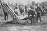 H G Gilmour, fl 1945 : Members of 24 Battalion readying an assault pontoon bridge for an exercise over the Lamone River, Italy