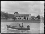 Two men in a motor boat looking toward Russell