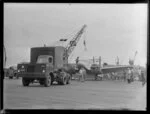Airforce mobile crane lowering a Cessna aircraft onto the wharf, Auckland