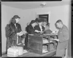 Australian National Airways, overseas passengers with Mr C Evans, Resident Customs Officer, Whenuapai Aerodrome, Auckland