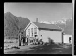 Teacher and pupils standing outside Weheka School, Fox Glacier, West Coast Region