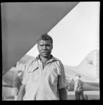 Aboriginal petrol attendant [Jackie?] next to Qantas Empire Airways aircraft, Northern Territory, Australia