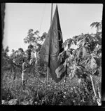 Unidentified man raising Qantas Empire Airways flag, Berrimah, Darwin, Australia