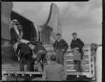 Old Vic Theatre Company luggage is unloaded from an Australian National Airways aircraft [Constellation?] by unidentified men at Whenuapai Royal New Zealand Air Force base