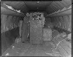 Old Vic Theatre Company luggage is unloaded from an Australian National Airways aircraft [Constellation?] by four unidentified men at Whenuapai Royal New Zealand Airforce base