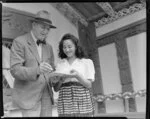 Sir Peter Buck signing autograph book for an unidentified girl at Marae, Ngāruawāhia, Waikato