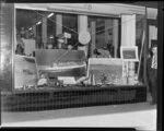 Marine hardware display, John Burns shop window with Whites Aviation photographs of ship, Aorangi, Auckland