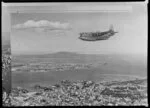 The Tasman Empire Airways Limited Short Solent flying boat RMA Ararangi (ZK-AMM) above Auckland City, including Waitemata Harbour, Devonport, and Rangitoto Island