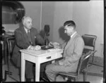 British Overseas Airways Corporation Chairman Sir Miles Thomas and photographer Leo Lemuel White (left to right) with a large microphone between them, location unknown