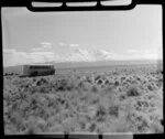 Landliner coach travelling through Tongariro National Park with Mount Ruapehu in the background