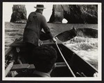 Captain Herbert Cook with unidentified male in boat in pursuit of whale