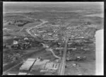 Close-up view of Penrose Southern Motorway under construction, Auckland City area, with Great South Road and railway, showing residential and commercial buildings, Mount Wellington and farmland beyond