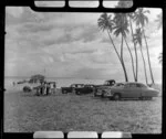 Satupuala Base, Upolu, Samoa, showing men, cars and TEAL (Tasman Empire Airways Limited) ZK-AMM flying boat at Samoa
