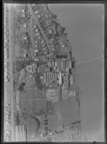 View over the New Zealand Refrigerating Company, Imlay Freezing Works Imlay Place, Wanganui, with stock pens and yards, showing Heads Road, Balgownie Avenue and Beach Road surrounded by residential housing, located beside the Wanganui River with wharf for loading ships