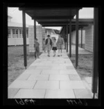 Children standing on walkway between dormitories at the Otaki Health Camp