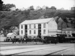 Crowd outside the Union Steam Ship Company building, Port Chalmers, and a Baldwin T Class locomotive