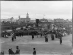 The Square, Palmerston North, during a parade of World War I troops, showing mounted infantry to the right of band rotunda , spectators, and city buildings including Palmerston North Post Office in background