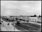 Pahiatua, Tararua District, view from upper floor building of Main Street showing fenced grass median strip street divider with people on horseback and in horse drawn coaches, and local businesses buildings - Commercial & Family Hotel