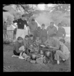 A group of scouts cooking a meal over a campfire, Wainuiomata, Lower Hutt