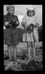 Two children, with kina in their hands, in the Awanui district, Northland