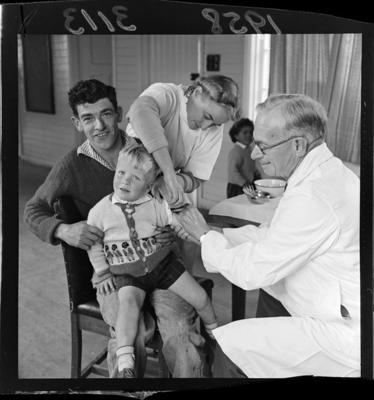 Image: An unidentified child with his father getting a polio vaccination at Titahi Bay